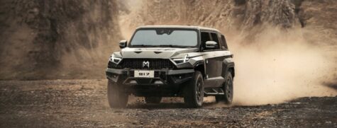 Melns elektro bezceļa auto M-Hero brauc pa bezceļu